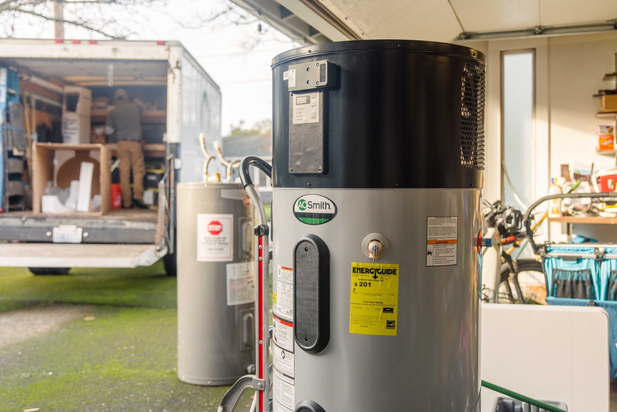 Heat pump water heater with an EnergyGuide sticker showing an estimated yearly cost of $201